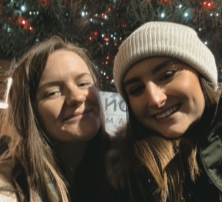 Sophie and Marty from the Epix Team smiling in front of a Christmas tree in the Nottingham Winter Wonderland